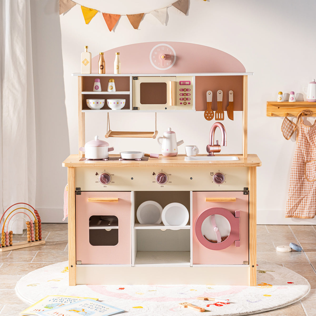 ROBUD Pink Wooden Kitchen PlaySet main kitchen counter with stove, sink and upper shelving in warm playroom light