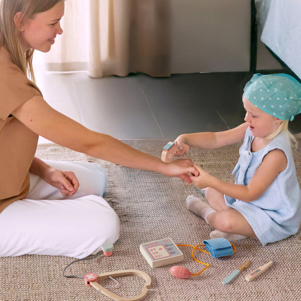 Young child and adult playing doctor together using ROBUD wooden medical toy set with stethoscope and examination tools