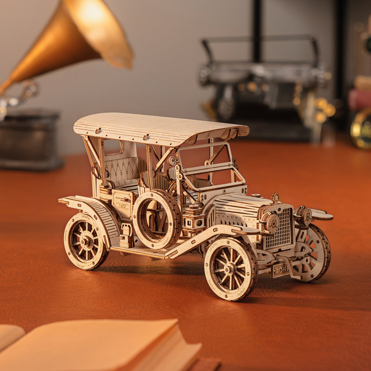 ROKR Vintage Car MC801 natural wood classic car on a wooden desk next to a golden brass gramophone