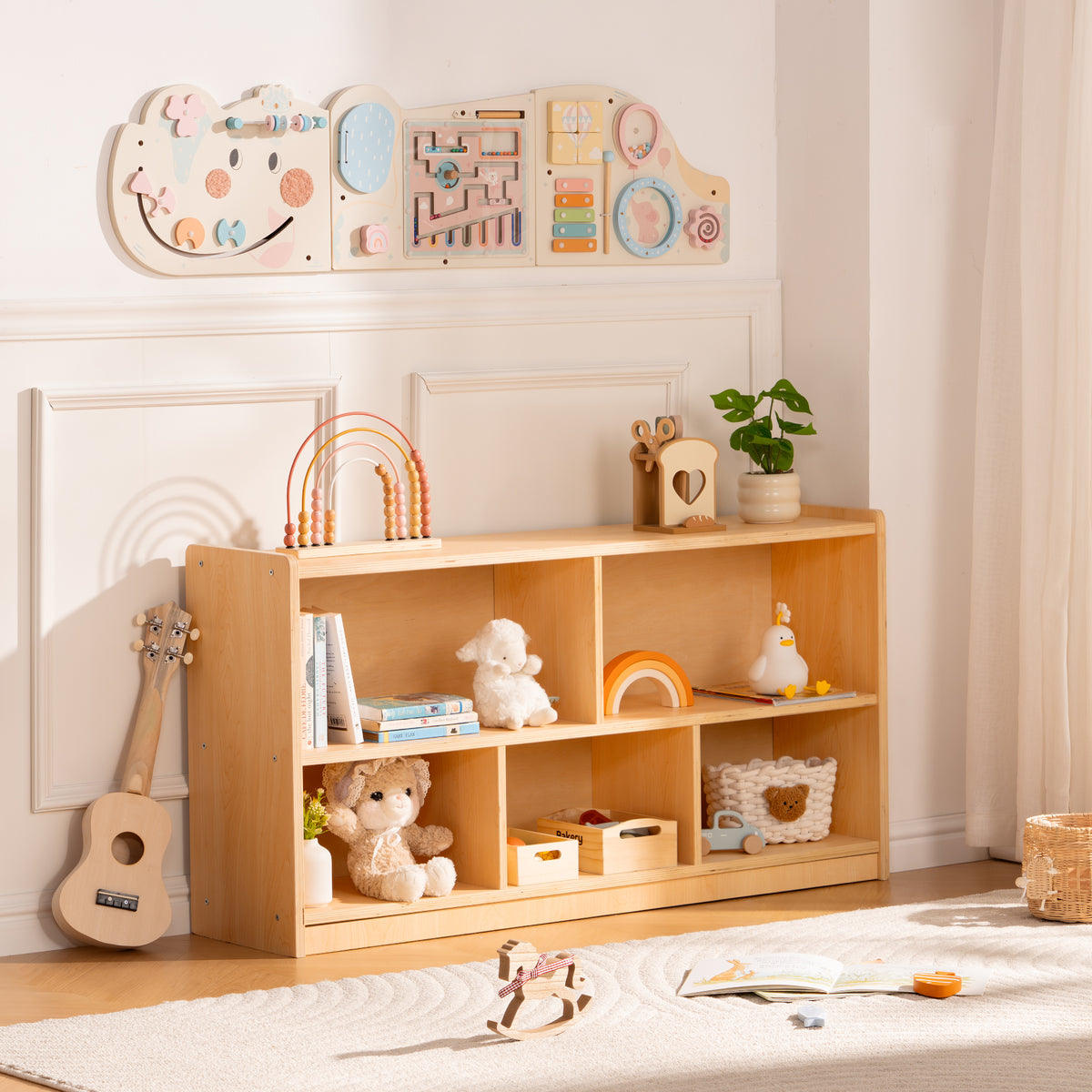 ROBUD open wooden bookshelf with five cubbies filled with children's toys and books in a light airy playroom setting.