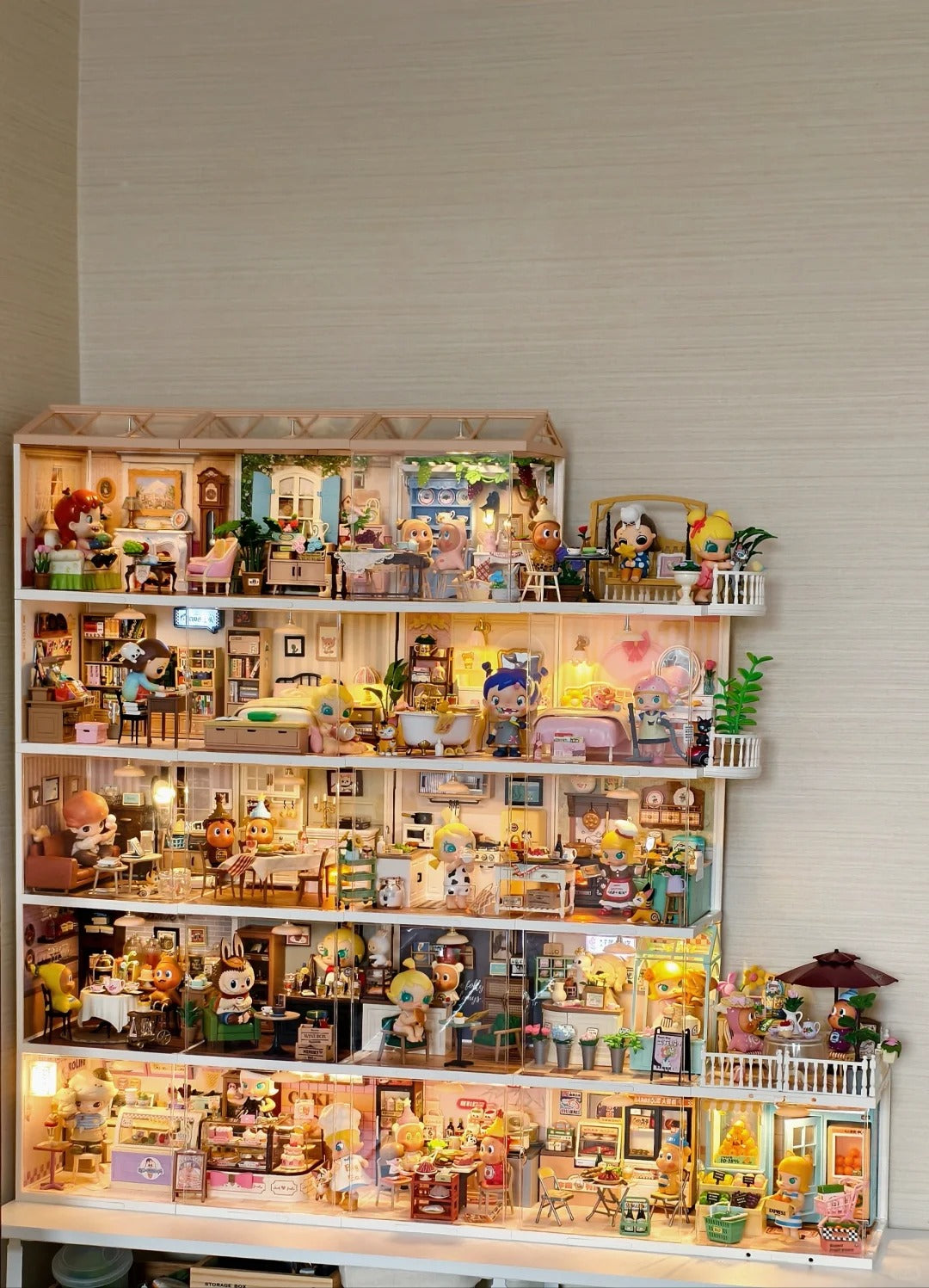 Wall display shelf showcasing a large Rolife miniature kit collection with over twelve illuminated wooden diorama models