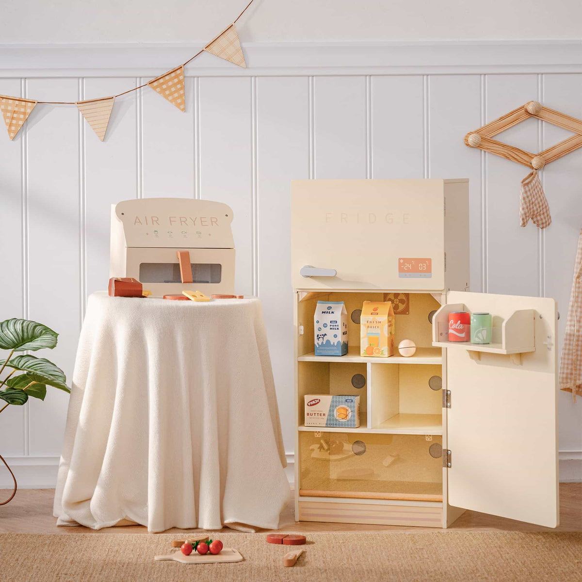 ROBUD creamy wooden play fridge open showing interior shelves stocked with milk, fresh juice, butter cartons, and cola and lemon cans on door shelf