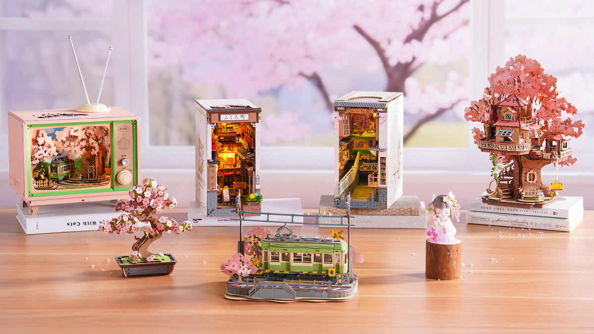 Rolife Sakura Densya TGB01 book nook alongside Rolife Sakura Wine Alley on a wooden shelf with warm amber lighting in a lifestyle scene