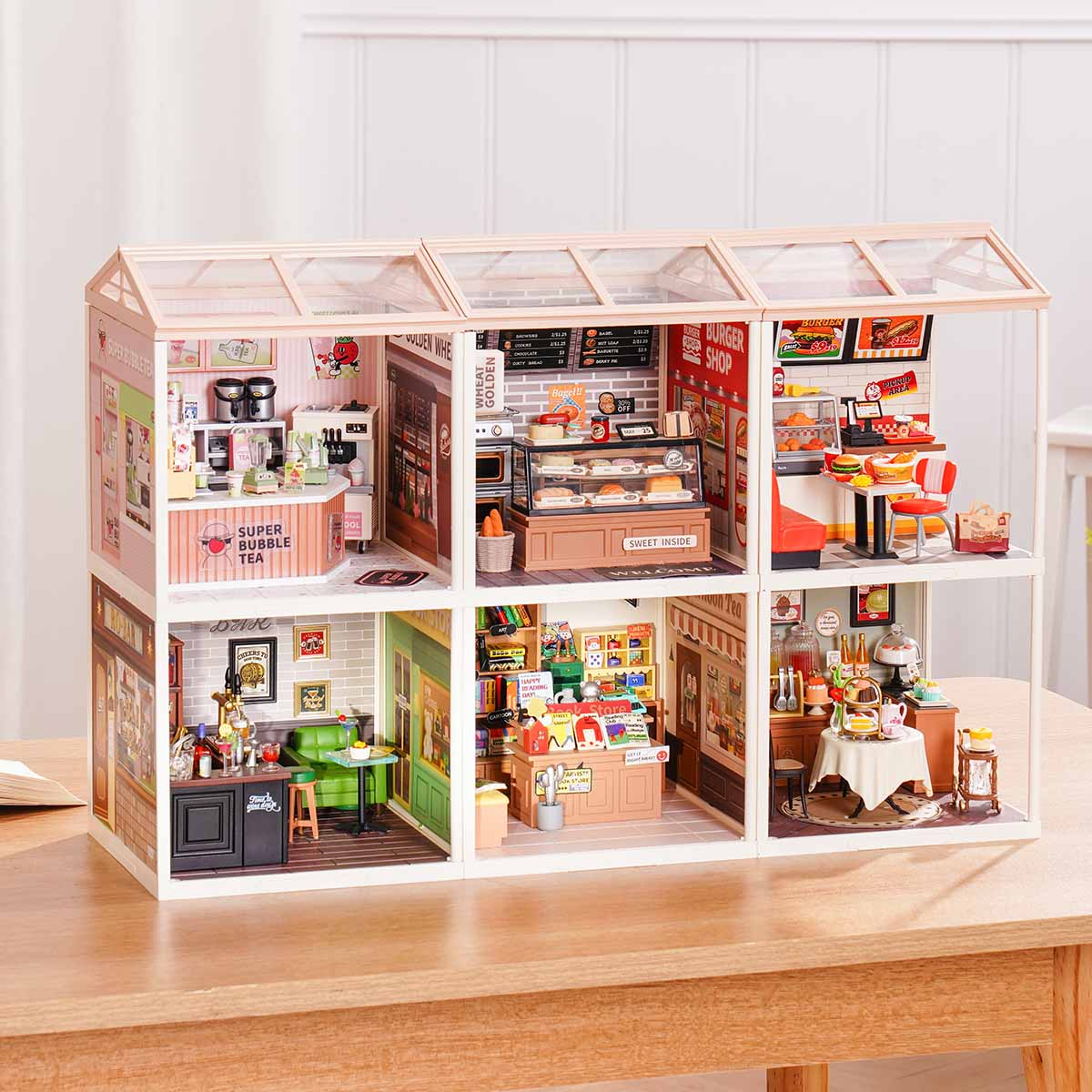 Rolife Super Creator Series 6-in-1 Six Grid miniature with six rooms showing a burger diner, afternoon tea cafe, bar, ice cream shop, cake bakery, and flower shop in a wide white frame.