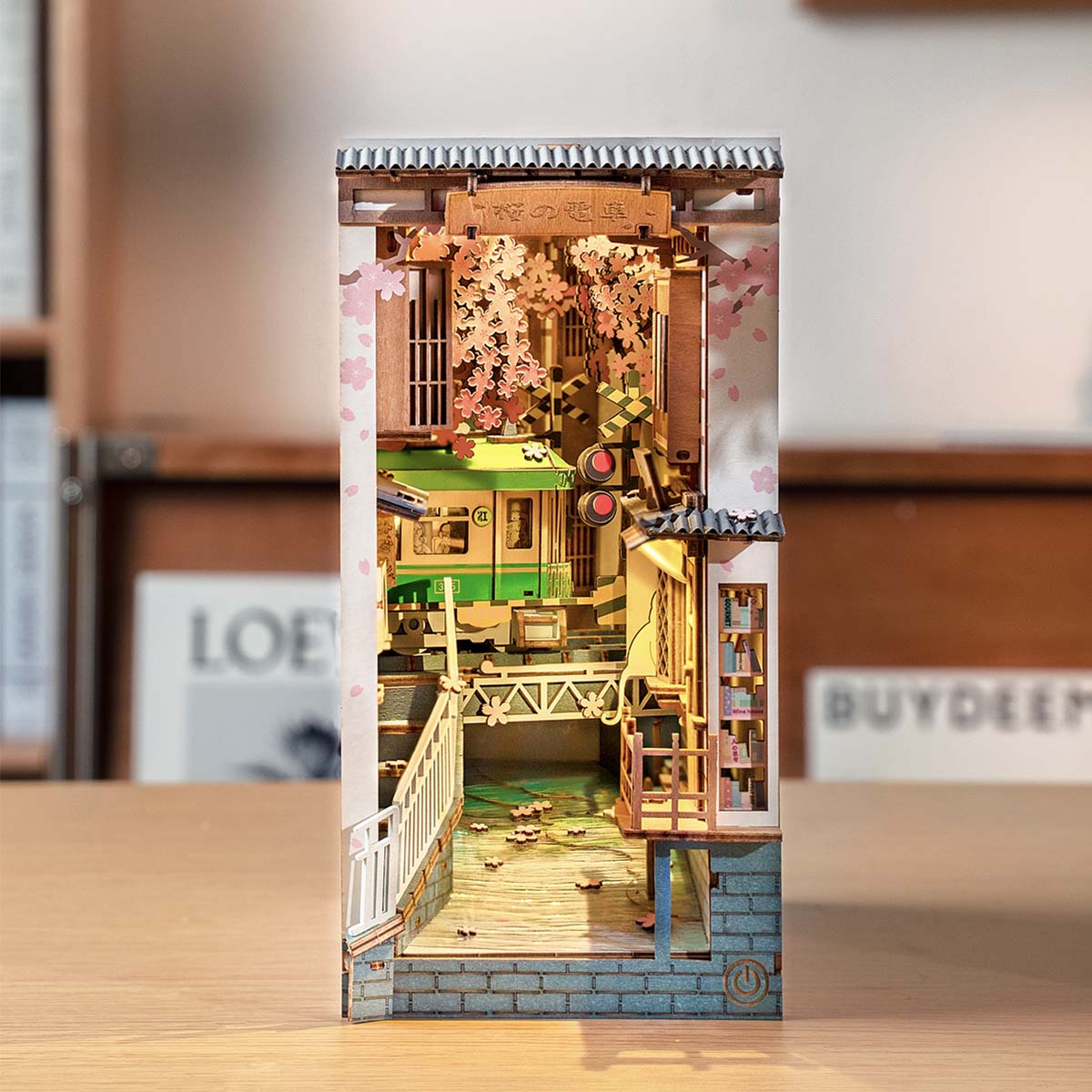 Rolife Sakura Densya book nook insert with pink cherry blossoms and wooden bridge detail on shelf
