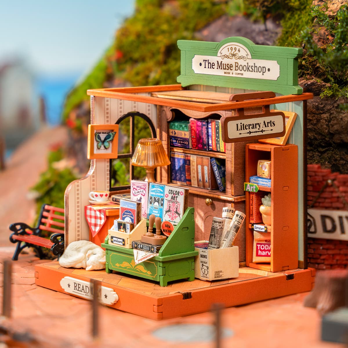 Rolife Muse Bookshop DS040 miniature storefront with green sign, tiny book shelves, butterfly display and park bench