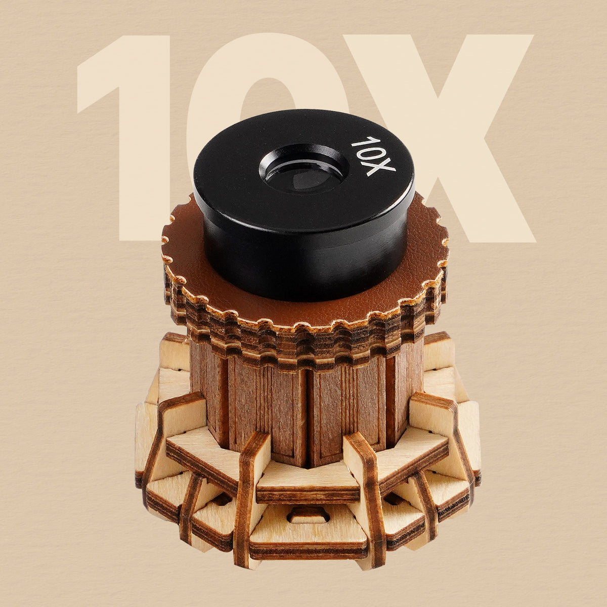 ROKR wooden microscope 10X objective lens shown close-up with a round black lens cap and golden wood gear base on tan background