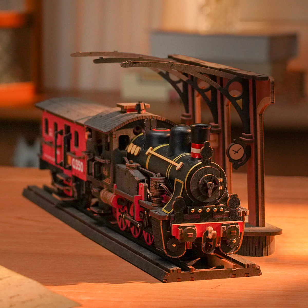 Rolife Steam Journey black and red locomotive rests on a warm wooden tabletop.