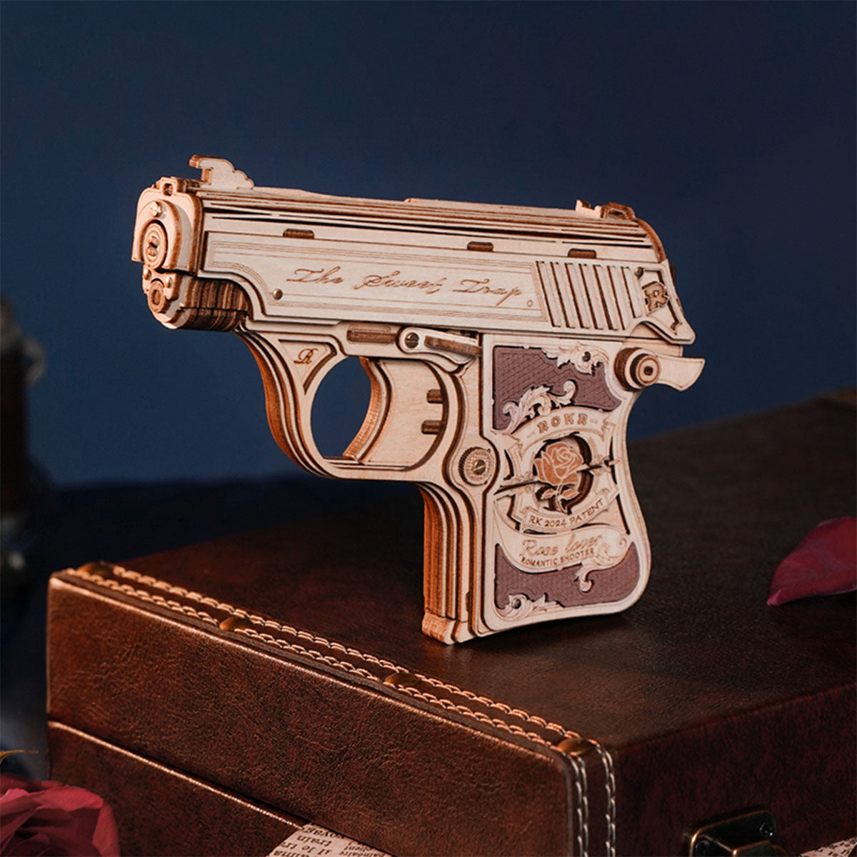 ROKR wooden mini gun puzzle model standing on a small wooden display base.