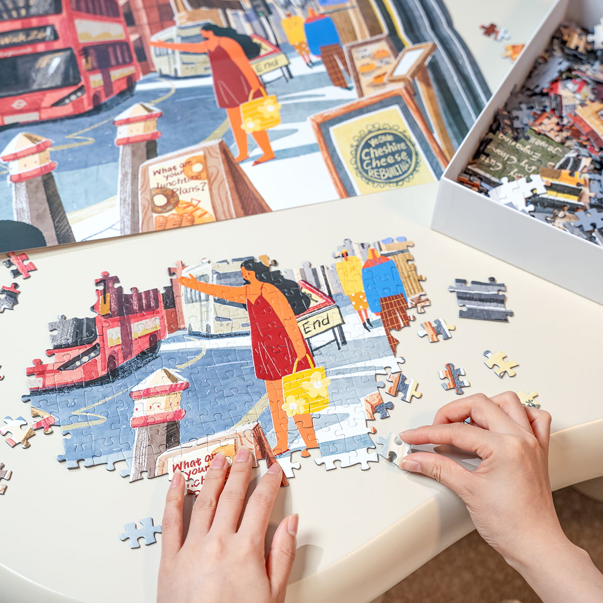 Hands assembling Rolife Walk in London jigsaw puzzle PT003 on a table showing colorful red bus and street scene pieces