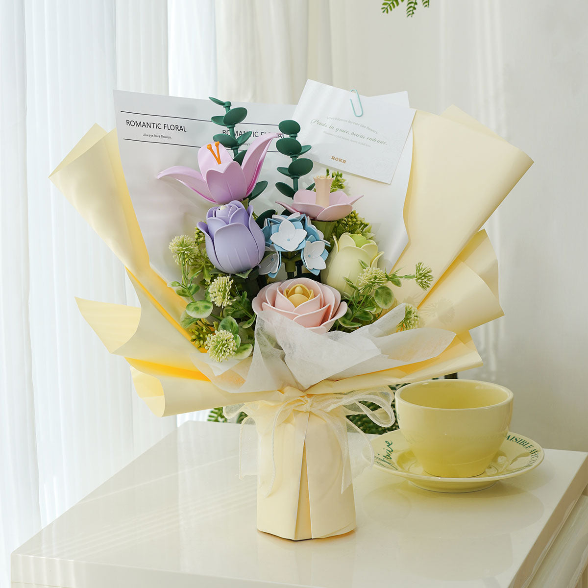 ROKR Spring Time Bouquet in a cream vase on a bright table beside a yellow teacup.