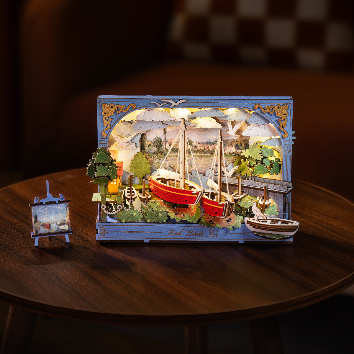 Rolife Red Boats 3D art frame with warm glowing LED lighting on a round table in a dimly lit room