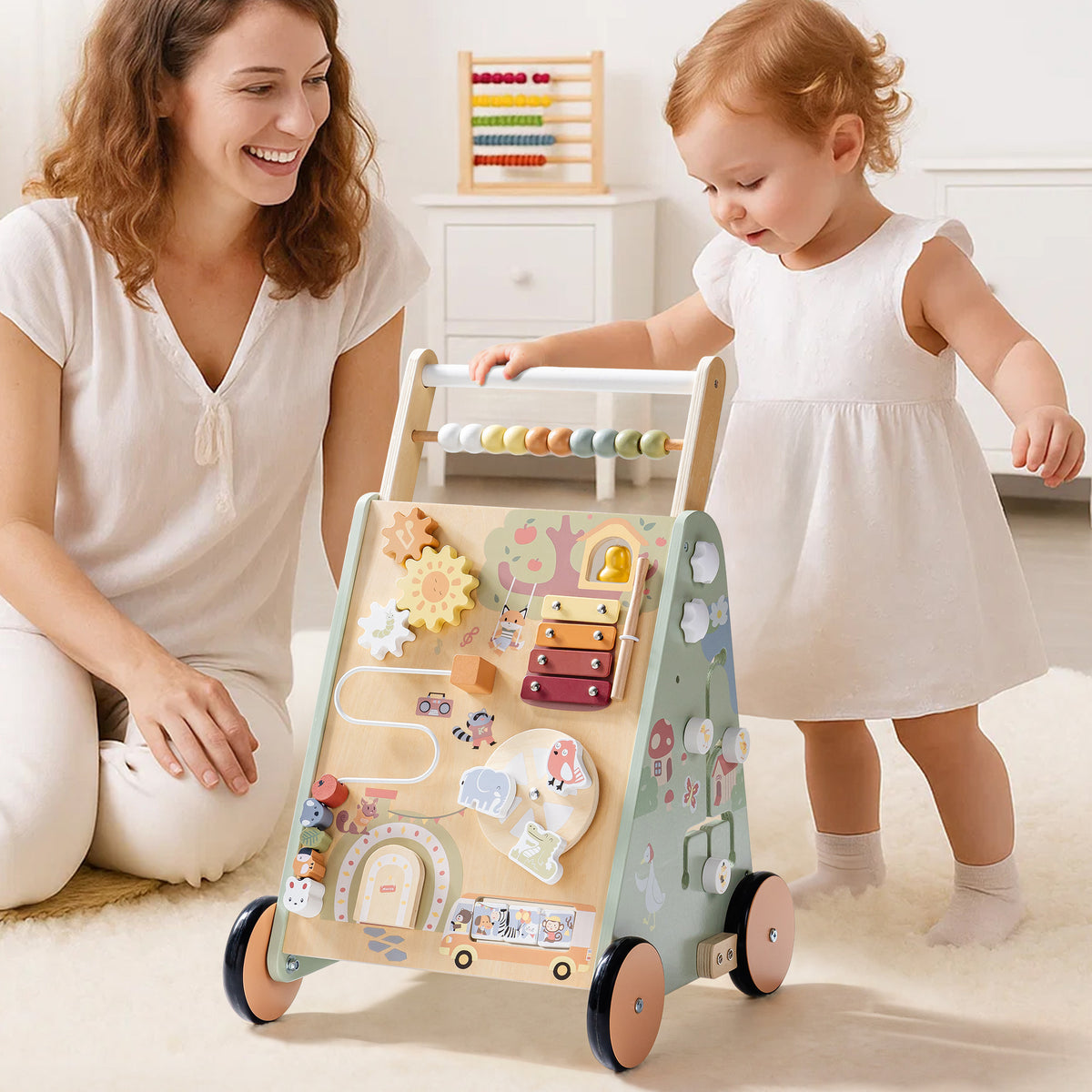 ROBUD Forest Fairy Baby Push Walker front lifestyle view with mother and toddler playing with the sage green fairy-themed wooden push walker with activity panel