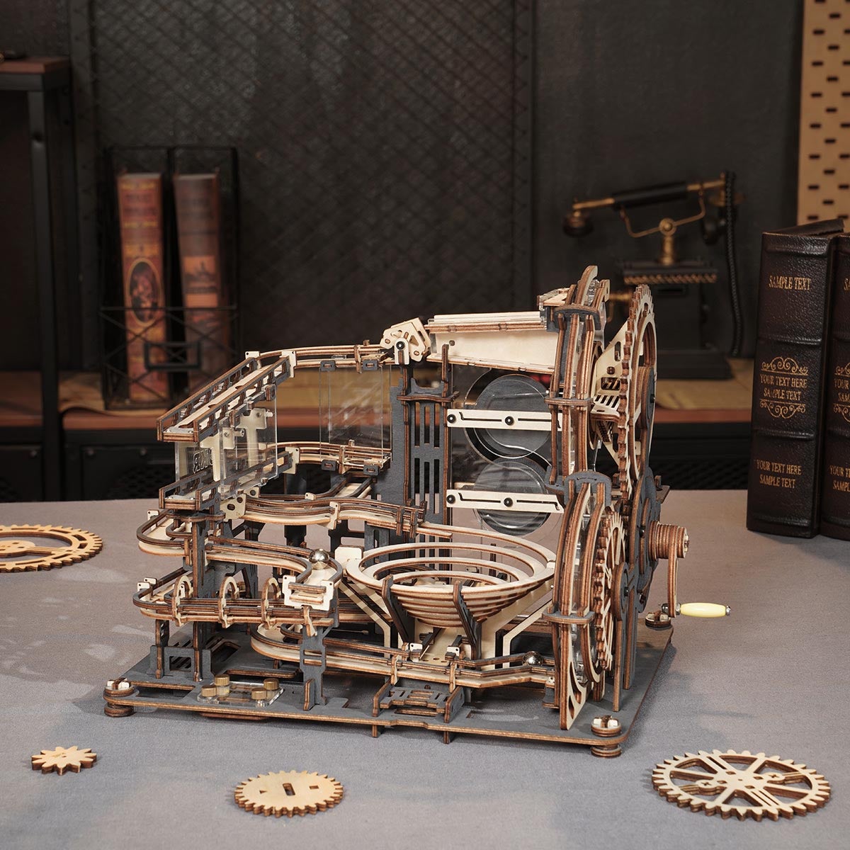 ROKR Marble Night City wooden marble run on a grey surface with scattered gears and dark bookshelves in the background