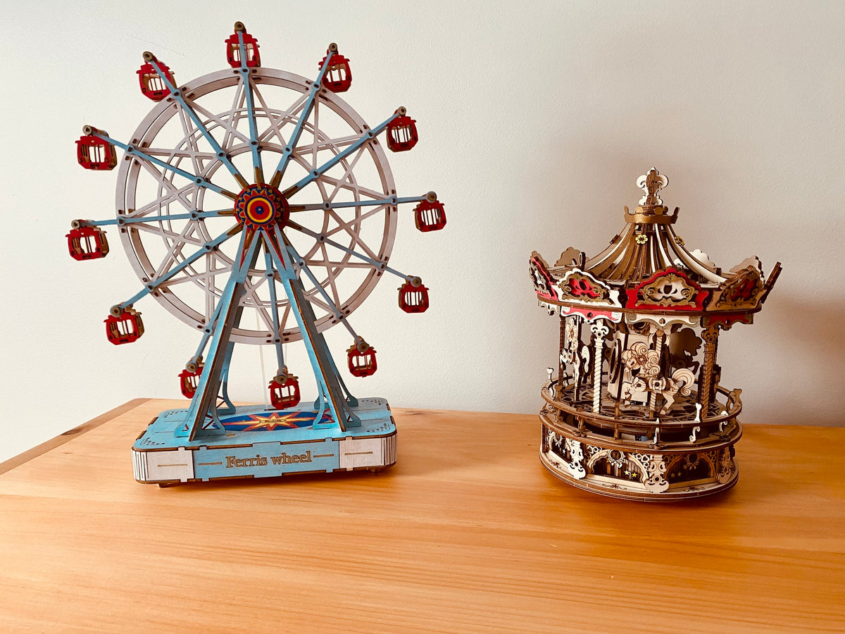 Robotime Ferris wheel and carousel models stand together on a tabletop.