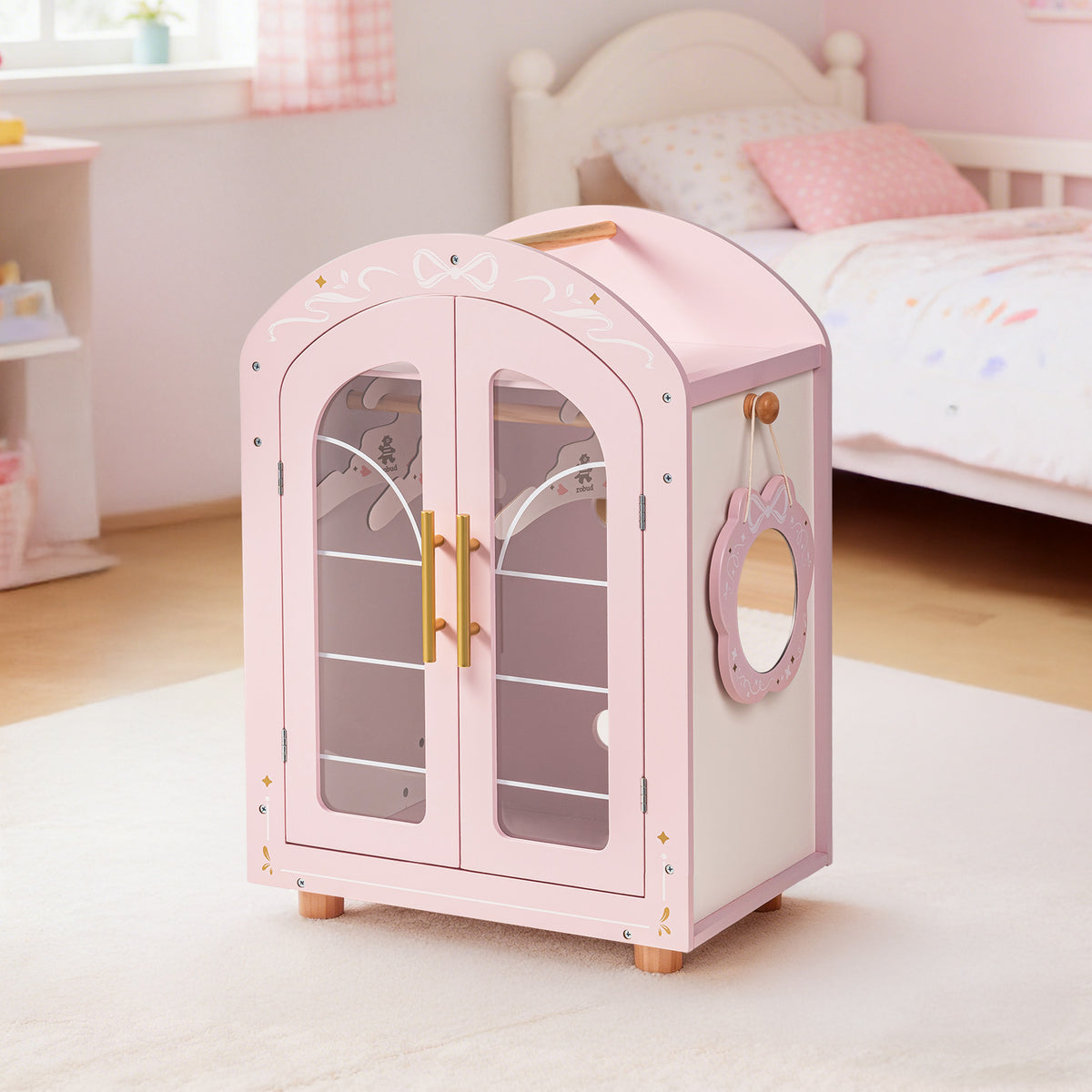 ROBUD pink doll wardrobe styled on a white rug in a pink bedroom with a canopy and teddy bear in the background.