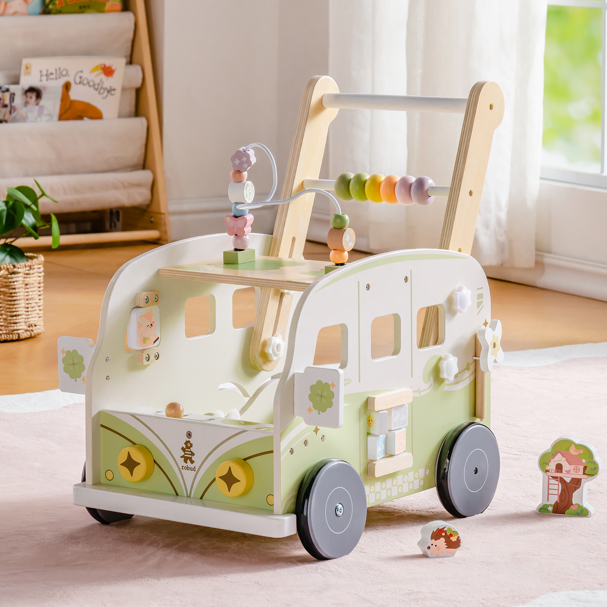 ROBUD green vacation bus wooden walker standing on a pink play mat with forest characters and small scattered toys.