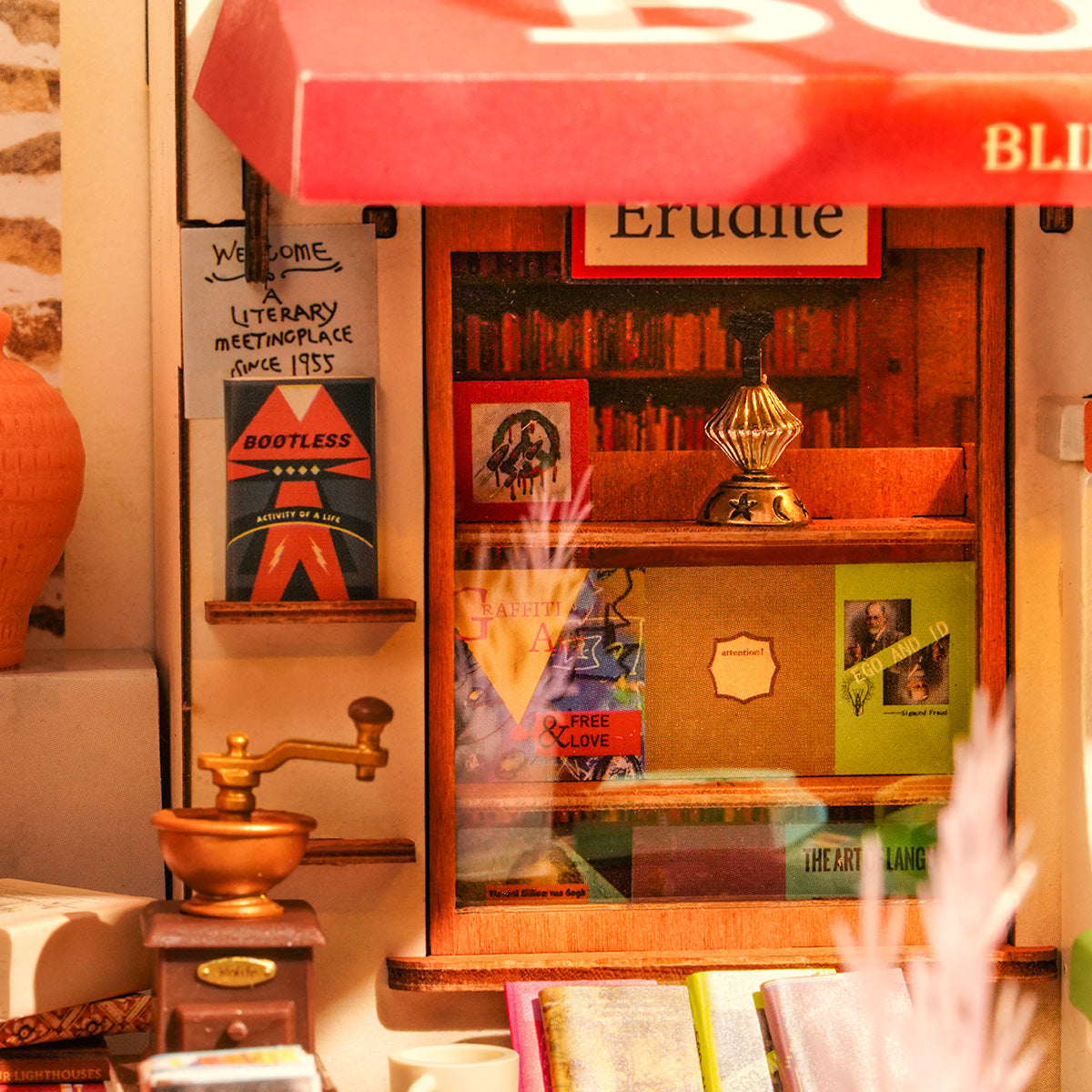 Close-up of the Rolife Corner Bookstore miniature storefront window displaying tiny books, a brass globe, and a miniature coffee grinder on warm wooden shelves