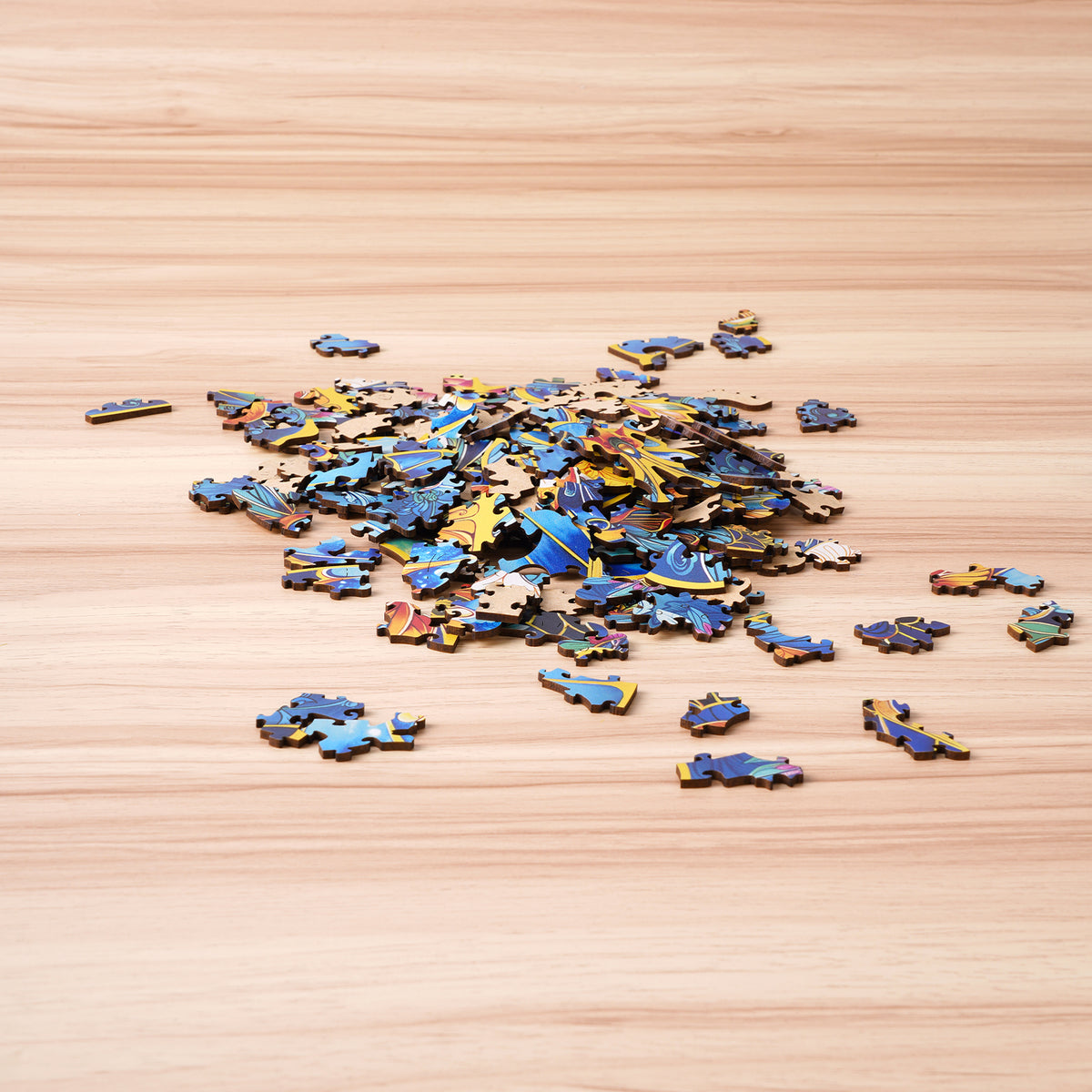 Rowood Morpho Helena wooden puzzle pieces scattered on a light wooden surface before assembly, showing colorful fragment details.