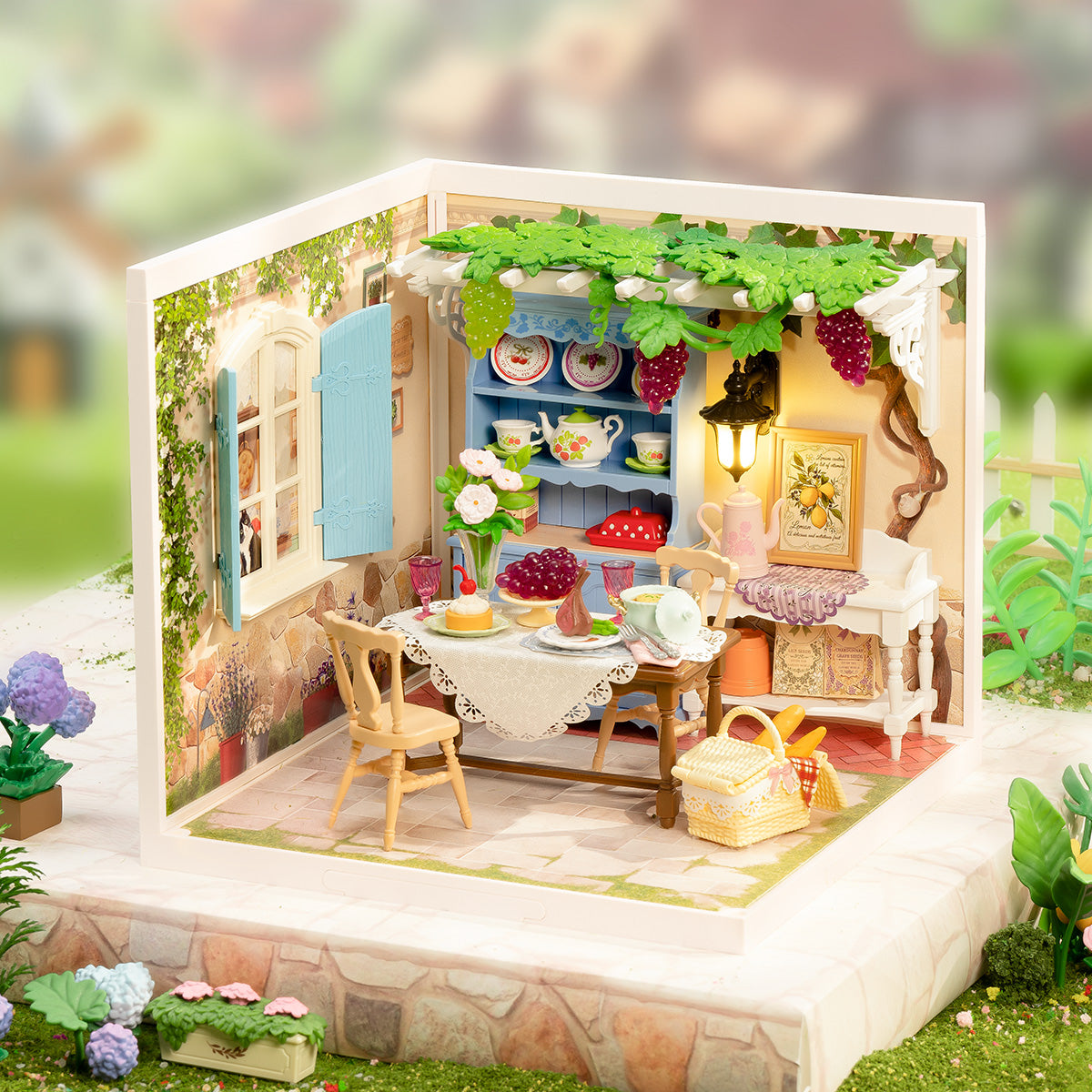 Rolife Midsummer Dream Yard DW025 open-corner scene with lace-cloth dining table and blue hutch displayed in a sunny garden setting