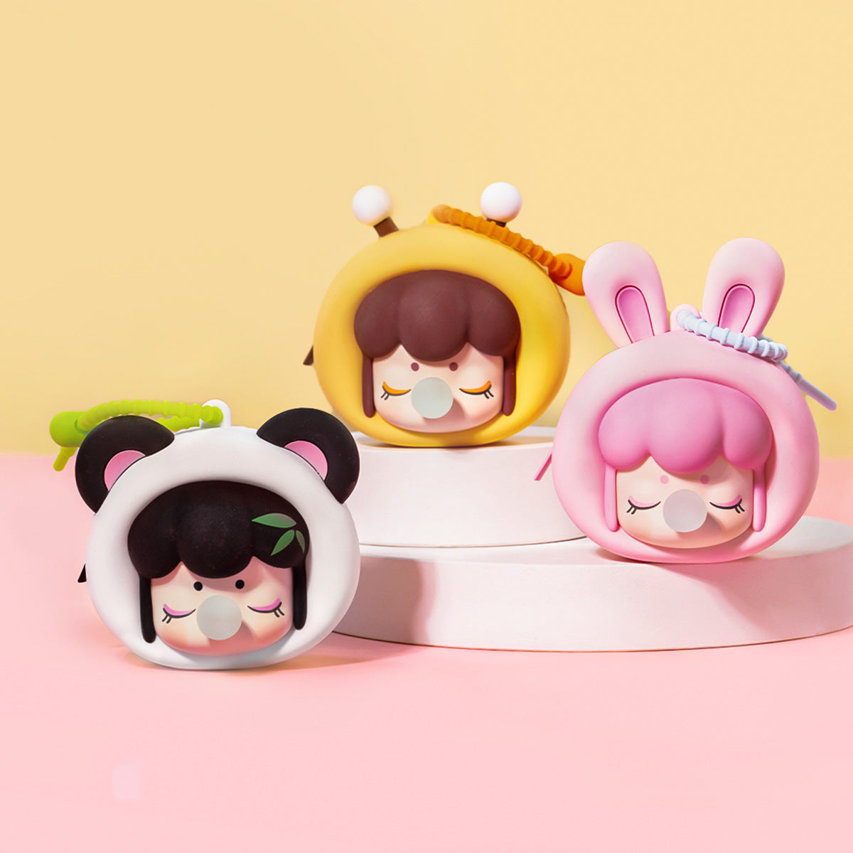 Rolife Baby Nanci Fluffy Party Headphone Case product title hero showing three round character cases on stepped platforms with confetti and party banners