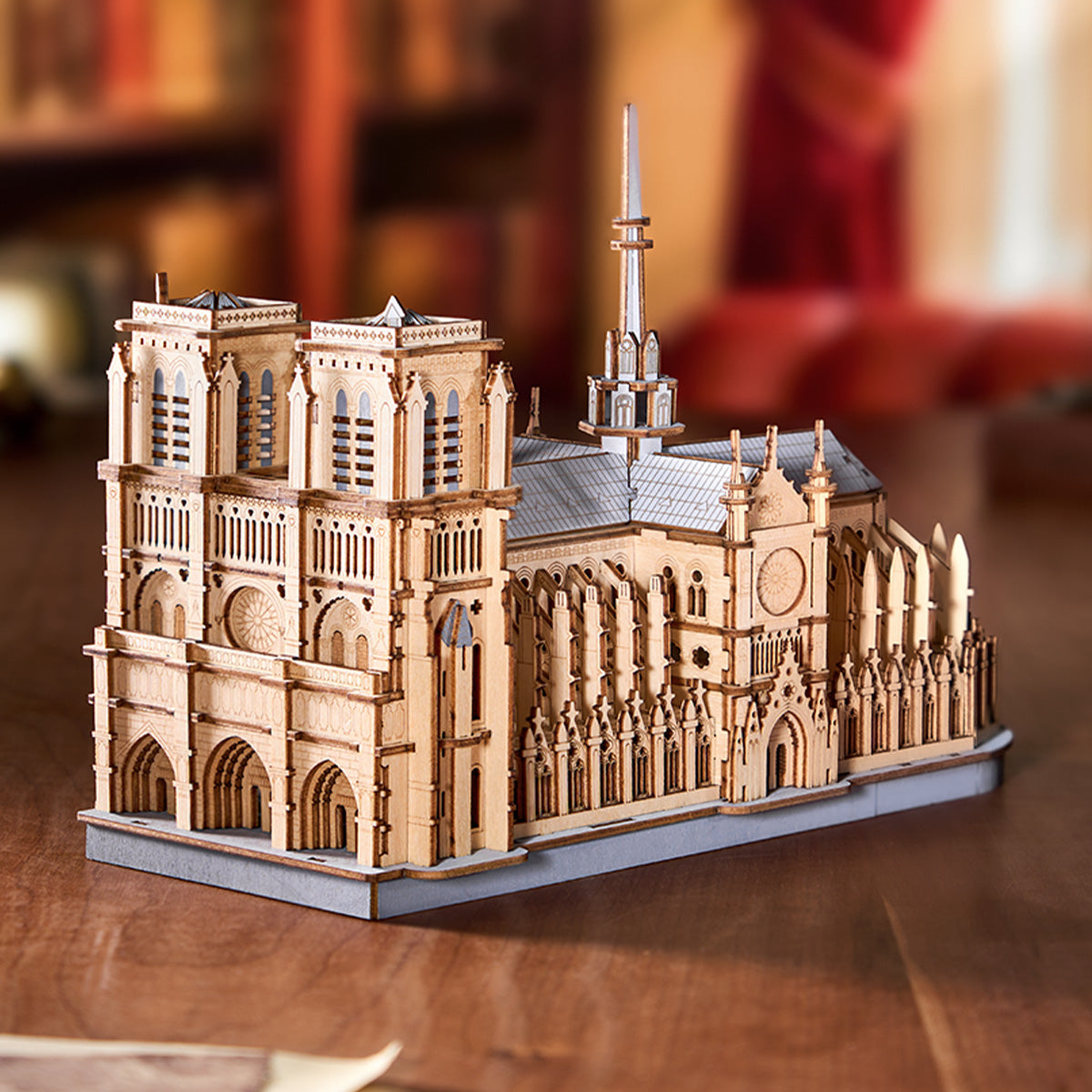 Rowood Paris Cathedral TG511 wooden puzzle three-quarter front view on a wooden desk beside a vintage book stack in a warmly lit library setting