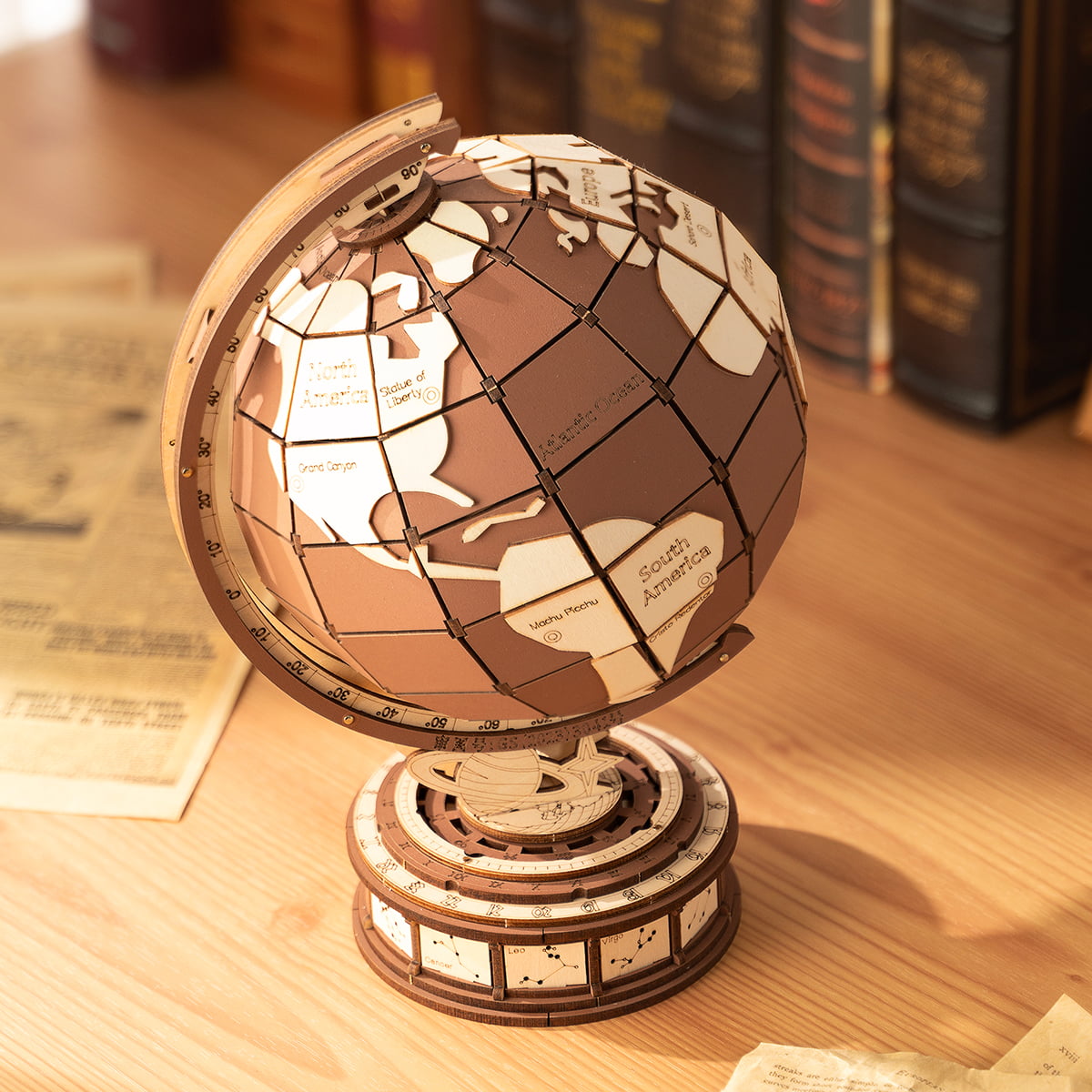 Assembled wooden world globe on a multi-tiered cylindrical base displayed on a wood surface with vintage books in the background