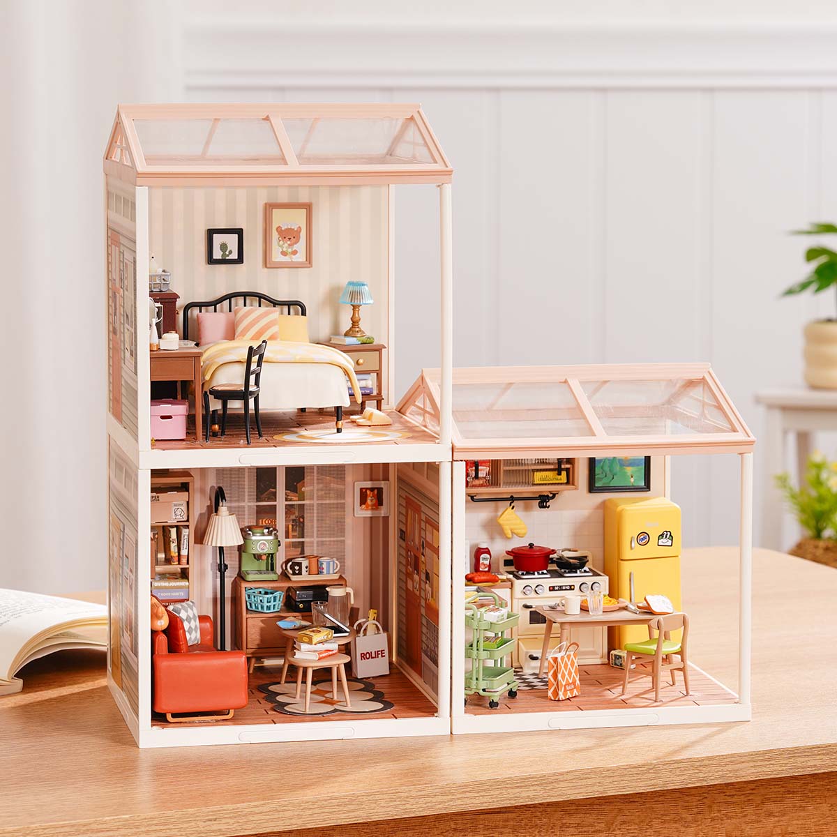 Rolife Super Creator Series 3-in-1 L Shape miniature set showing a bedroom and kitchen module stacked beside a separate lower module with living room and bath on a wooden surface.