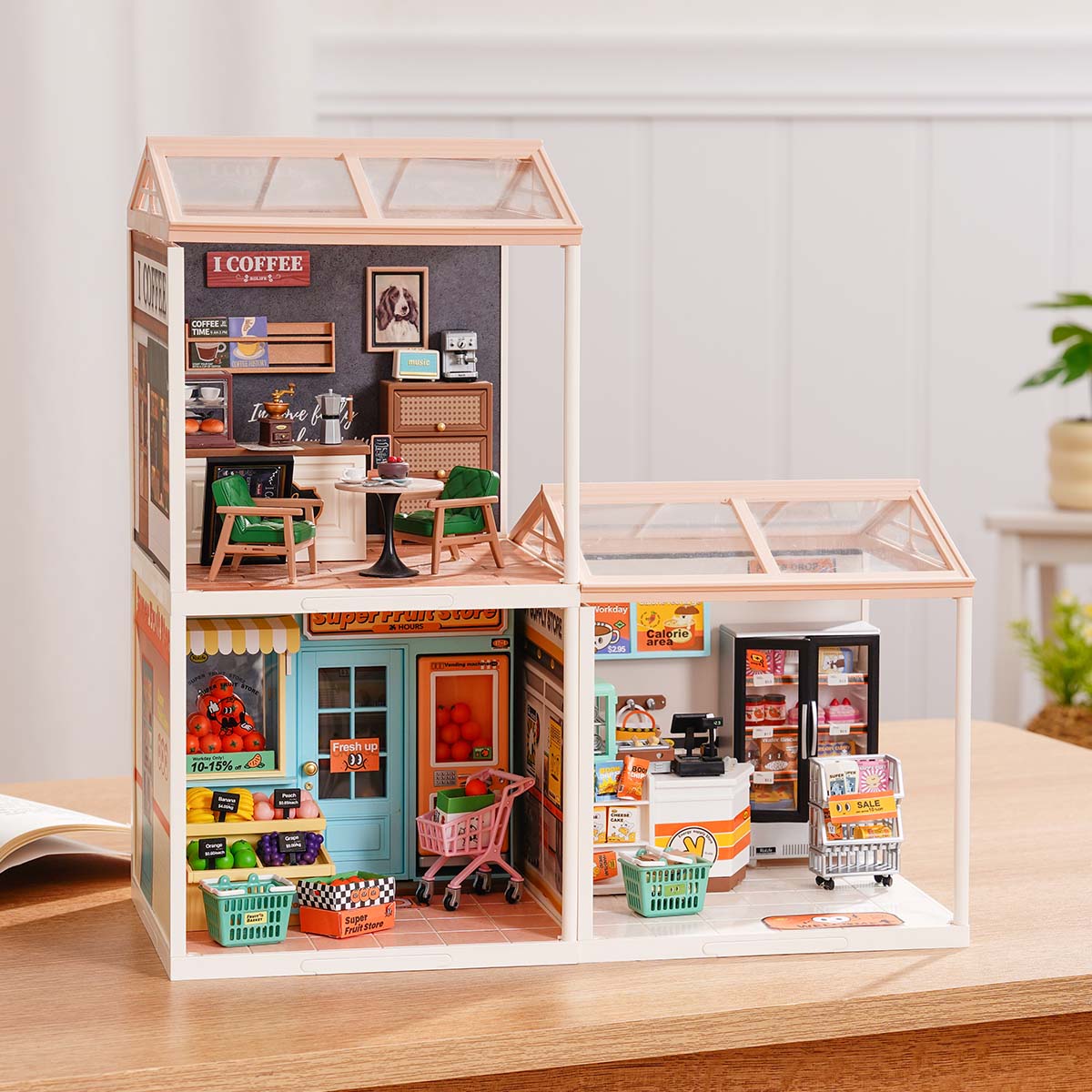 Rolife Super Creator Series 3-in-1 L Shape miniature with coffee shop and swing rooftop on top and a large supermarket plus fruit store spread in an L formation on a wooden surface.