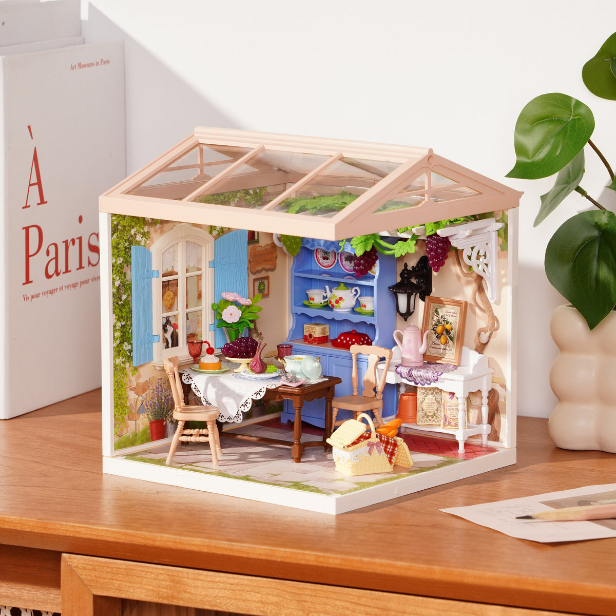 Rolife Midsummer Dream Yard DW025 miniature house on a desk showing a sunny garden terrace with flowers and wicker furniture