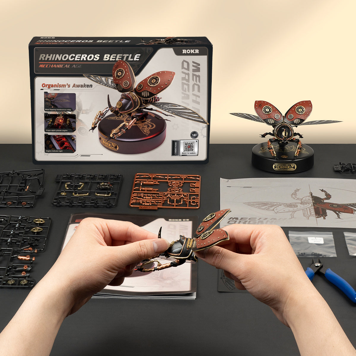 ROKR Rhinoceros Beetle 3D wooden puzzle kit with hands assembling parts on dark workbench surface
