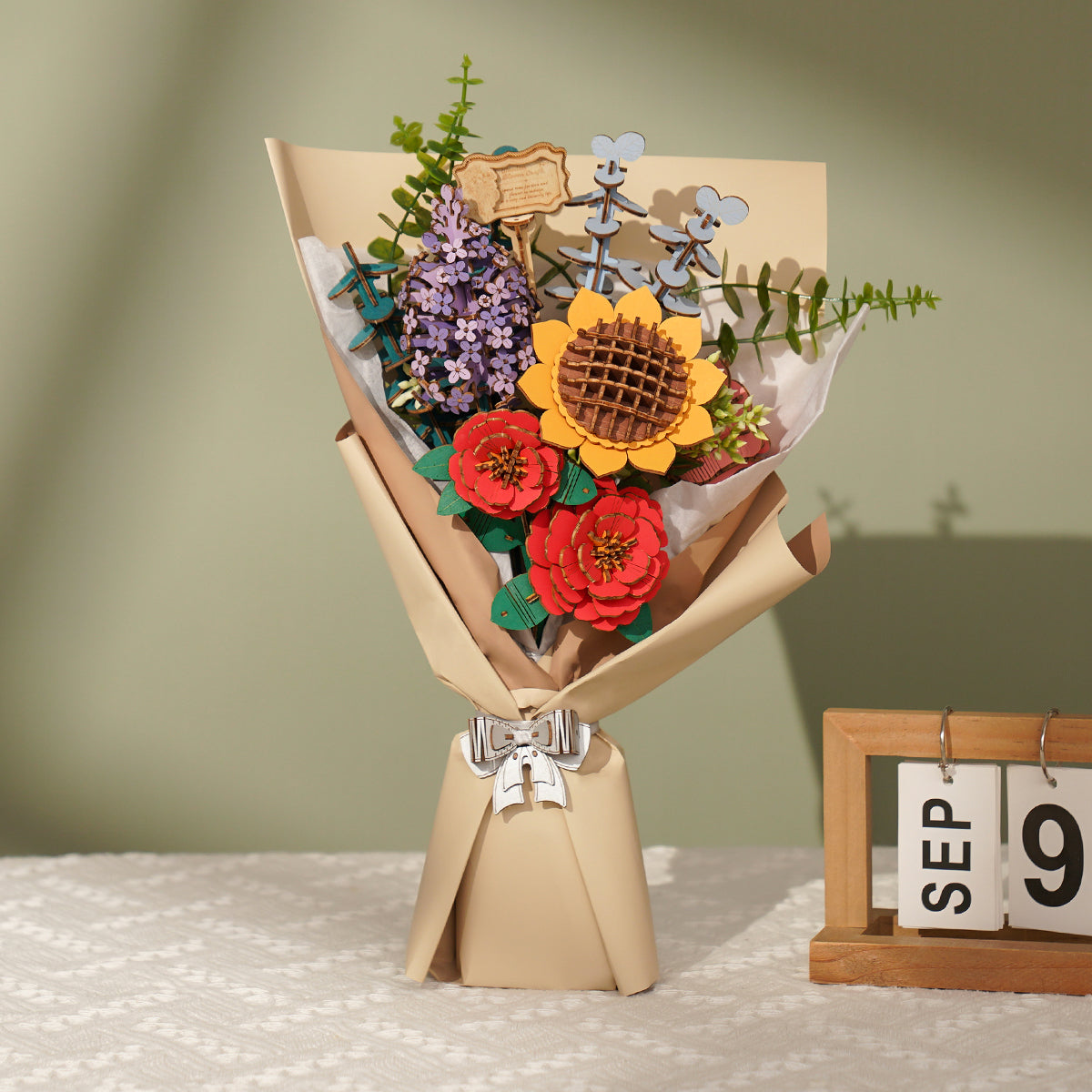 Rowood wooden flower bouquet stands in a vase with a sunflower, red blooms, and blue accents.