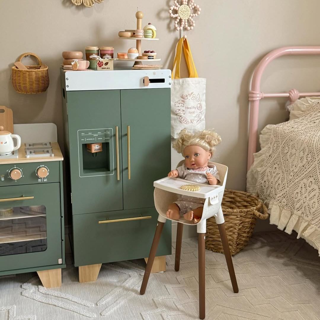 Toddler girl playing beside ROBUD vintage green refrigerator and play kitchen set in a pink and cream bedroom with wicker accents