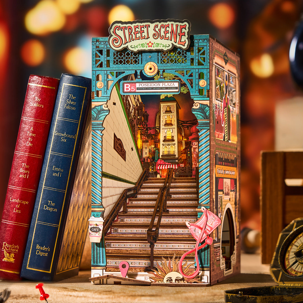 Rolife Street Scene TGB13 book nook angled side view showing musician mural panel and layered street scene resting on stacked magazines