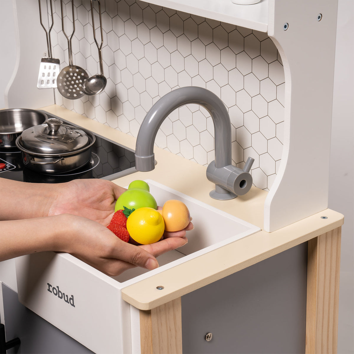 Robud vintage play kitchen close-up of deep sink basin with a hand washing colourful toy fruit