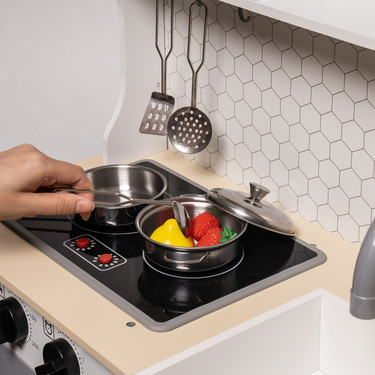 Robud modern vintage kitchen toy close-up of cooktop burners with a saucepan and lid in use