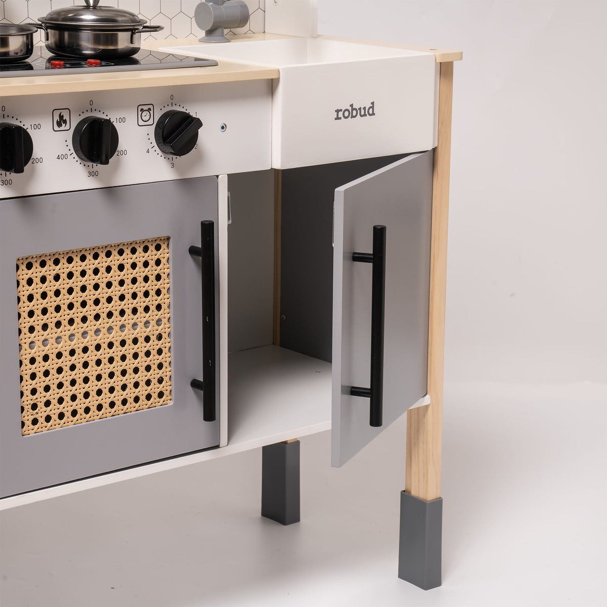 Robud vintage play kitchen lower oven door open showing rattan panel texture and storage inside