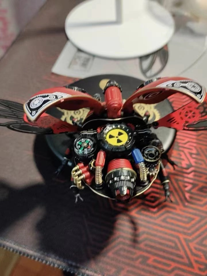 ROKR mechanical beetle model with spread wings, nuclear symbol body detail, and compass gauges on a wooden desk