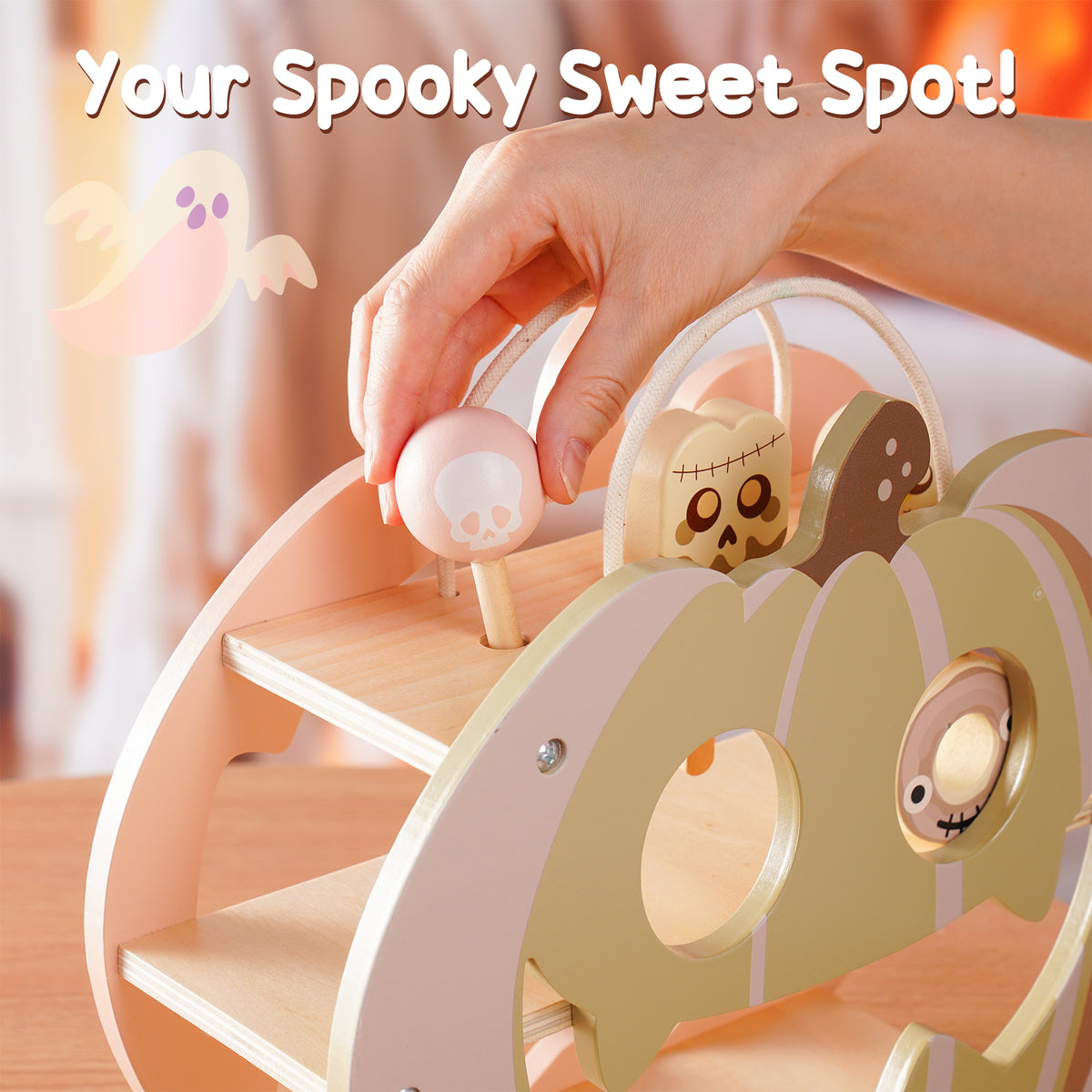 Child's hand placing a round candy figure into the ROBUD Halloween Candy House pumpkin playset in a Halloween-themed setting