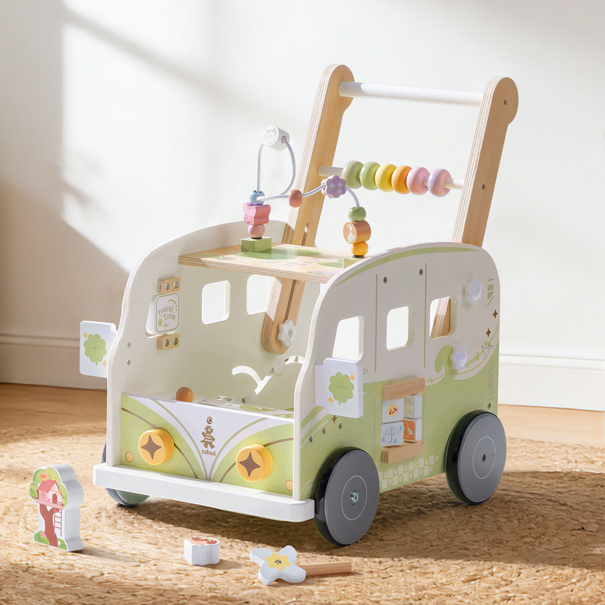 ROBUD green vacation bus wooden baby walker shown in a softly lit playroom with pastel props and rainbow bead details.