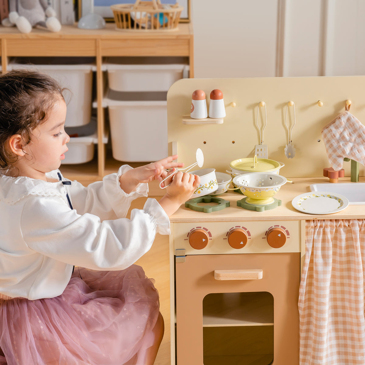 Toddler girl playing with pink saucepan at ROBUD Tinplate Pretend Cooking Utensils wooden play kitchen with microwave and oven