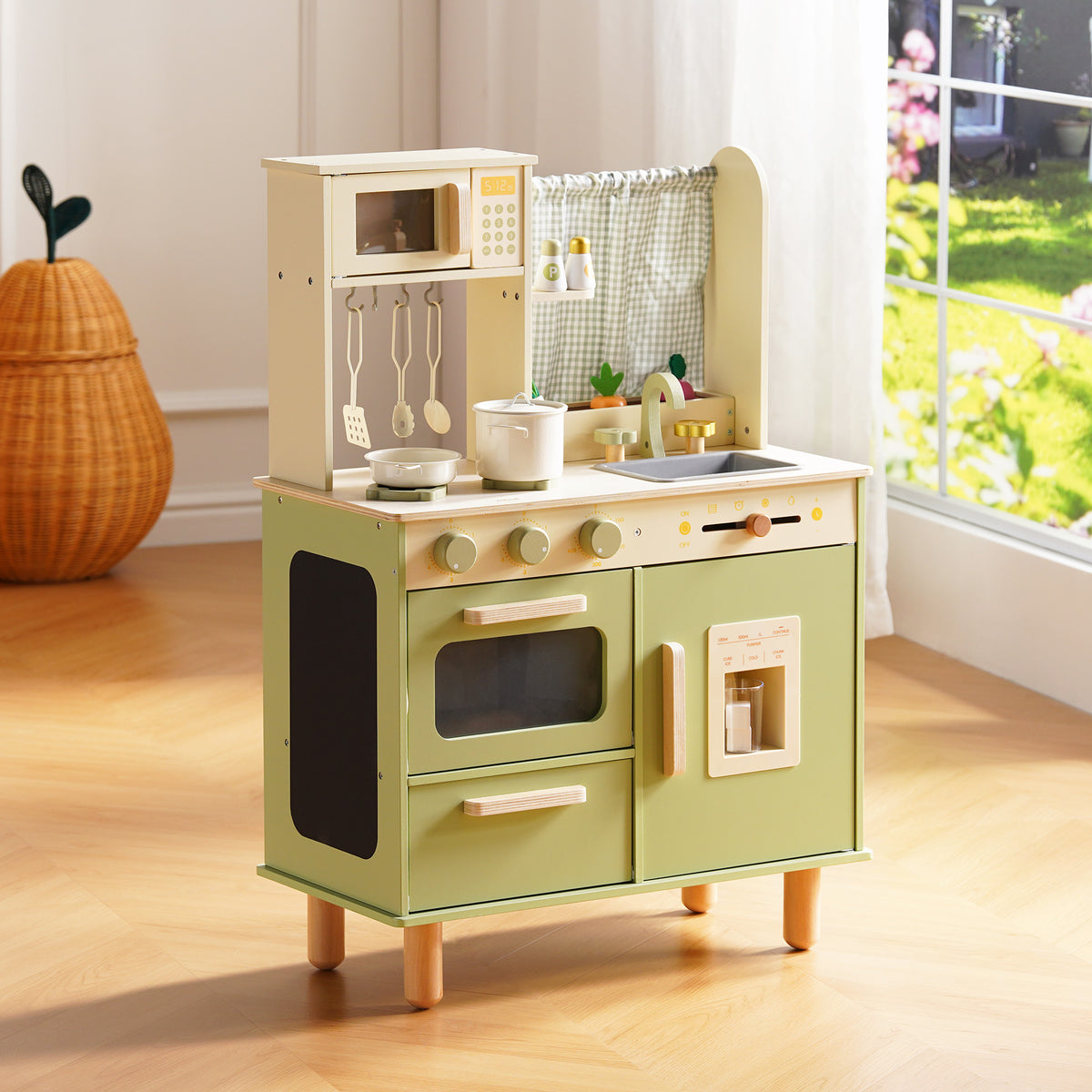 ROBUD sage green wooden play kitchen with oven, microwave, ice maker, and gingham curtain, photographed in a sunny playroom.