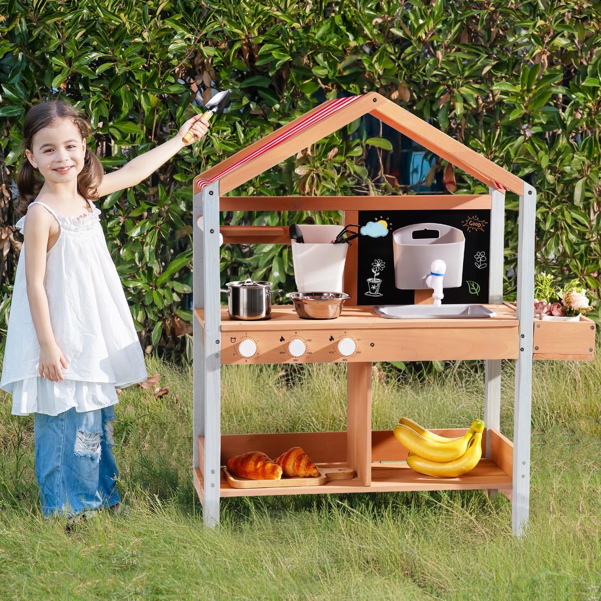 ROBUD outdoor mud kitchen with canopy displayed indoors with assorted fruits and vegetables on shelf below the striped canopy