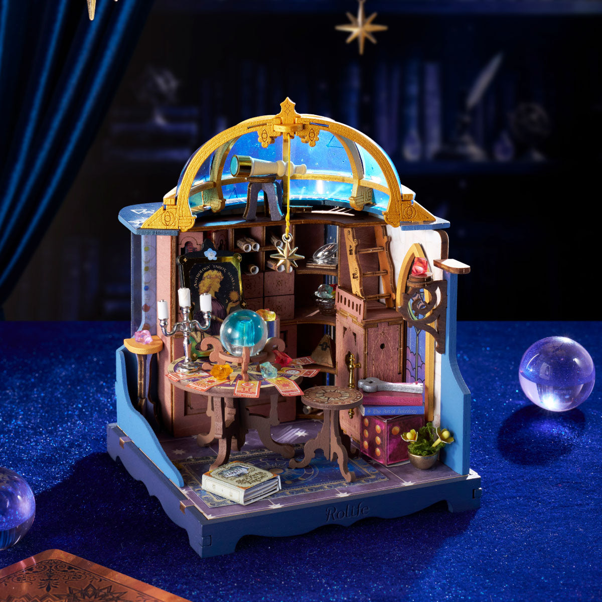 Rolife Astral Dome miniature displayed on deep blue velvet with telescope, crystal ball, tarot table, hanging star and glowing night-sky dome