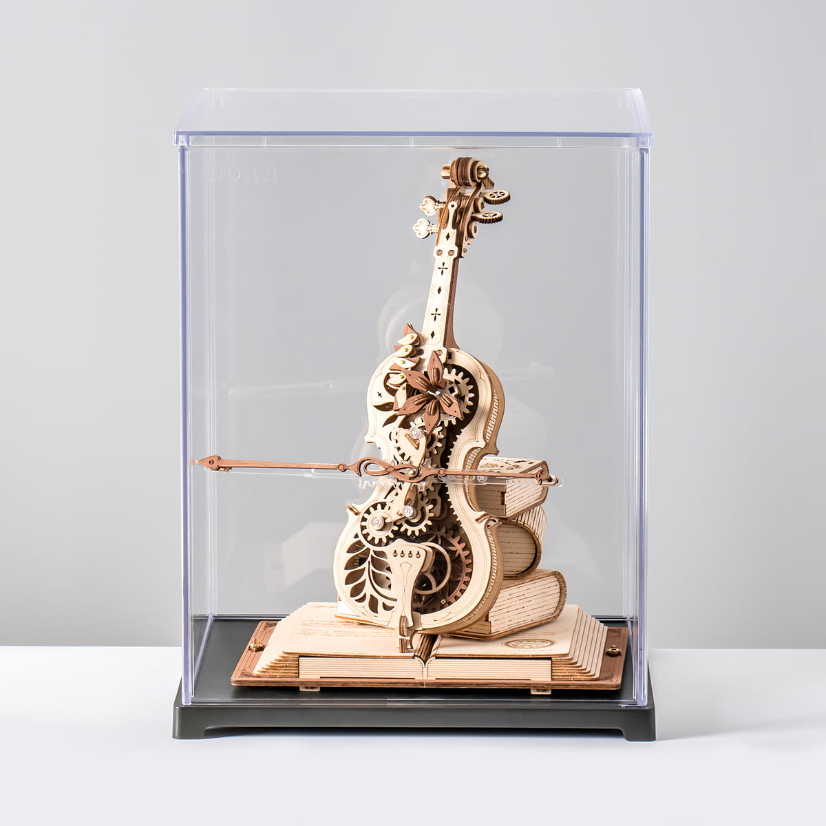 ROKR Magic Cello wooden music box inside a clear acrylic display case on a light gray background