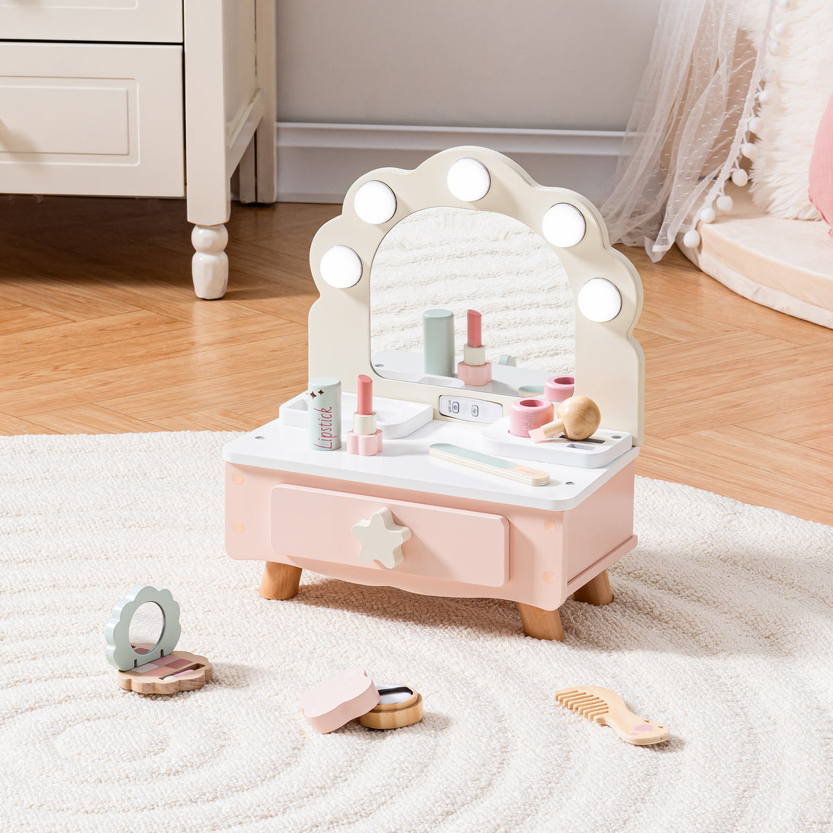 ROBUD pink wooden tabletop vanity on a white shag rug with wooden play makeup accessories scattered around the base.