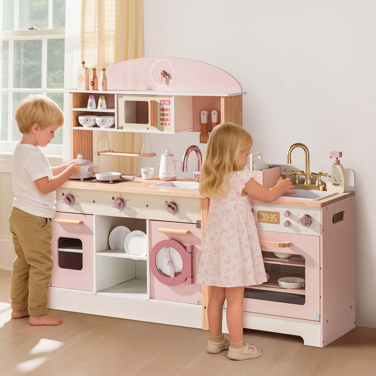 Two children playing at the ROBUD Pink Wooden Kitchen PlaySet with full counter, oven and sink unit