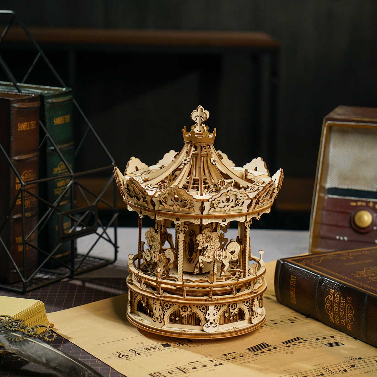 ROKR Romantic Carousel wooden music box on stack of antique books beside vintage radio and sheet music