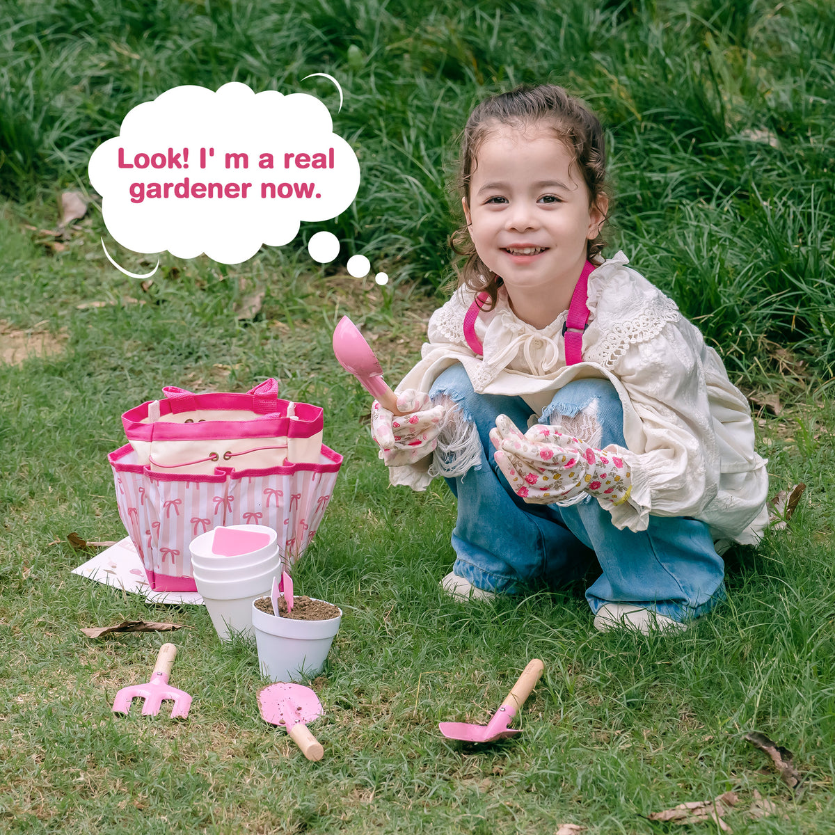 Young girl in apron kneeling in the garden with ROBUD Bow Gardening Set basket and tools proudly showing her real gardener skills