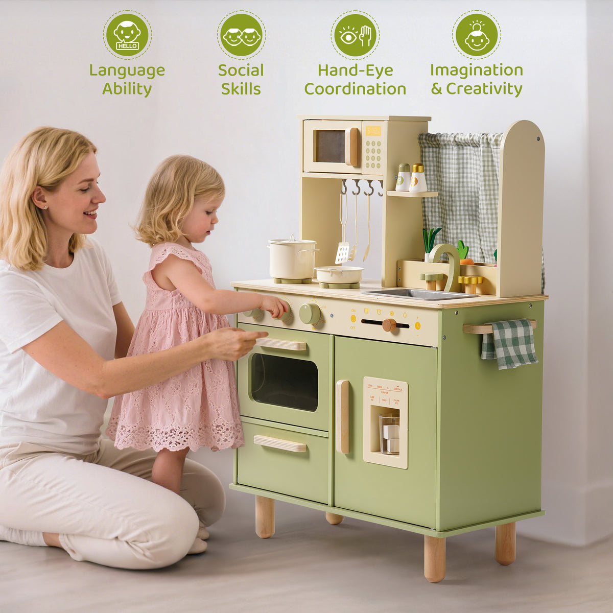 Mother kneels with daughter at the ROBUD green wooden play kitchen, skill icons highlight language and creative play.